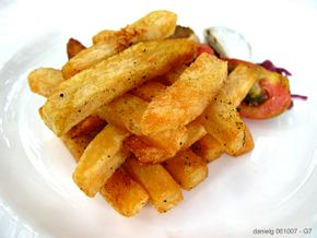 A unique french fry creation served at Antonio's Restaurant in Tagaytay City, Philippines. These have probably been prepared in drawn butter (butter with all the whey and other liquids removed) after a light coating in seasoning. Fresh chopped garlic has been added to flavor the fry medium and removed and sprinkled atop the final dish, which can be seen in the photo. Note the careful arrangement of the fries.