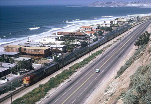 (PD) Photo: Jim Munding The southbound San Diegan passes through San Clemente, California in April, 1973. The cars and motive power still bear Santa Fe markings and livery. The nine-car consist includes five "High-Level" coaches.