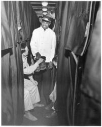 © Photo: Atchison, Topeka and Santa Fe RailwayA Pullman porter accepts a pair of boots to be polished from a soldier in a sleeping berth aboard an Atchison, Topeka and Santa Fe Railway military train.