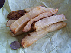 Potato log fries or simply potato logs, are prepared from very large unpeeled or peeled potatoes, often pre-cooked, that are cut about 1 inch (2.5 cm) by 1 inch (2.5 cm) to form "logs". A variant of potato logs is prepared similarly to wedge fries. Large, unpeeled, and often pre-cooked potatoes are are quartered or cut into sixths or eights lengthways to form the logs and prepared. Potato logs are sometimes prepared through various baking methods. Note the coin (U.S. quarter) in the photo for size comparison. This serving was probably made from just one extra large potato.