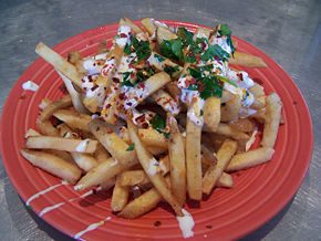 Urban fries is a dish popularized along the U.S. west coast. It consists of french fries topped with bleu cheese salad dressing, chili oil, and sprinkled with either chopped flat leaf parsley or cilantro for both color and flavor.