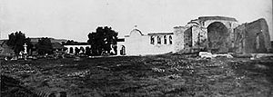 (PD) Photo: William Amos Haines An overall view of the "Mission of the Swallow" around the time of Father St. John O'Sullivan's arrival in 1910. The Mission's once-renowned California pepper tree can be seen just to the left of the adobe church's espadaña.
