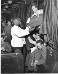 © Photo: Atchison, Topeka and Santa Fe Railway A Pullman porter assists soldiers returning from the South Pacific aboard an Atchison, Topeka and Santa Fe Railway troop train.