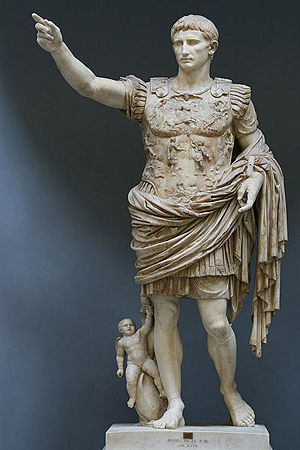 Picture of a statue of a man holding his arm up and wearing a toga.